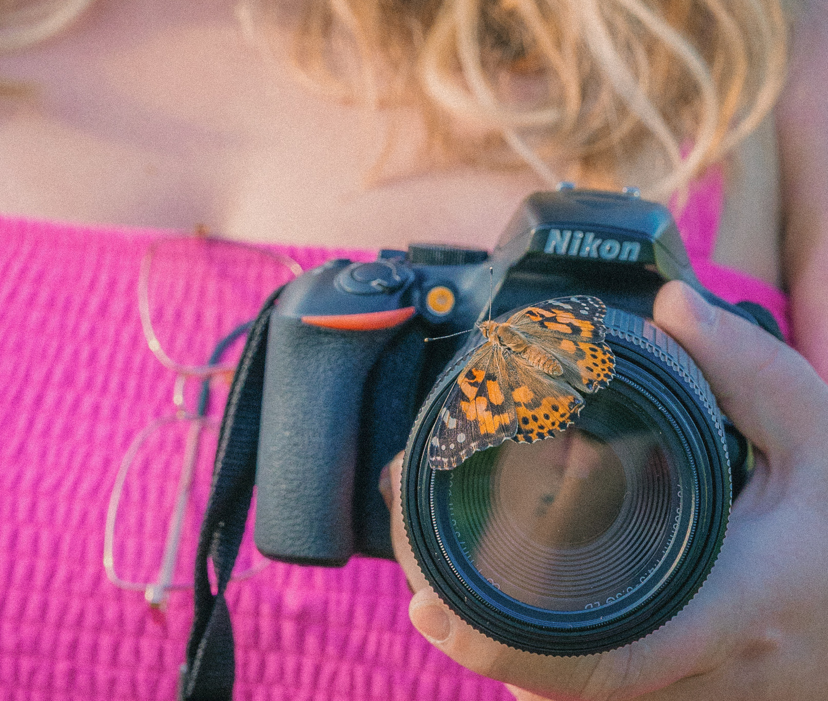 Anwen holding a camera with a butterfly landing on it