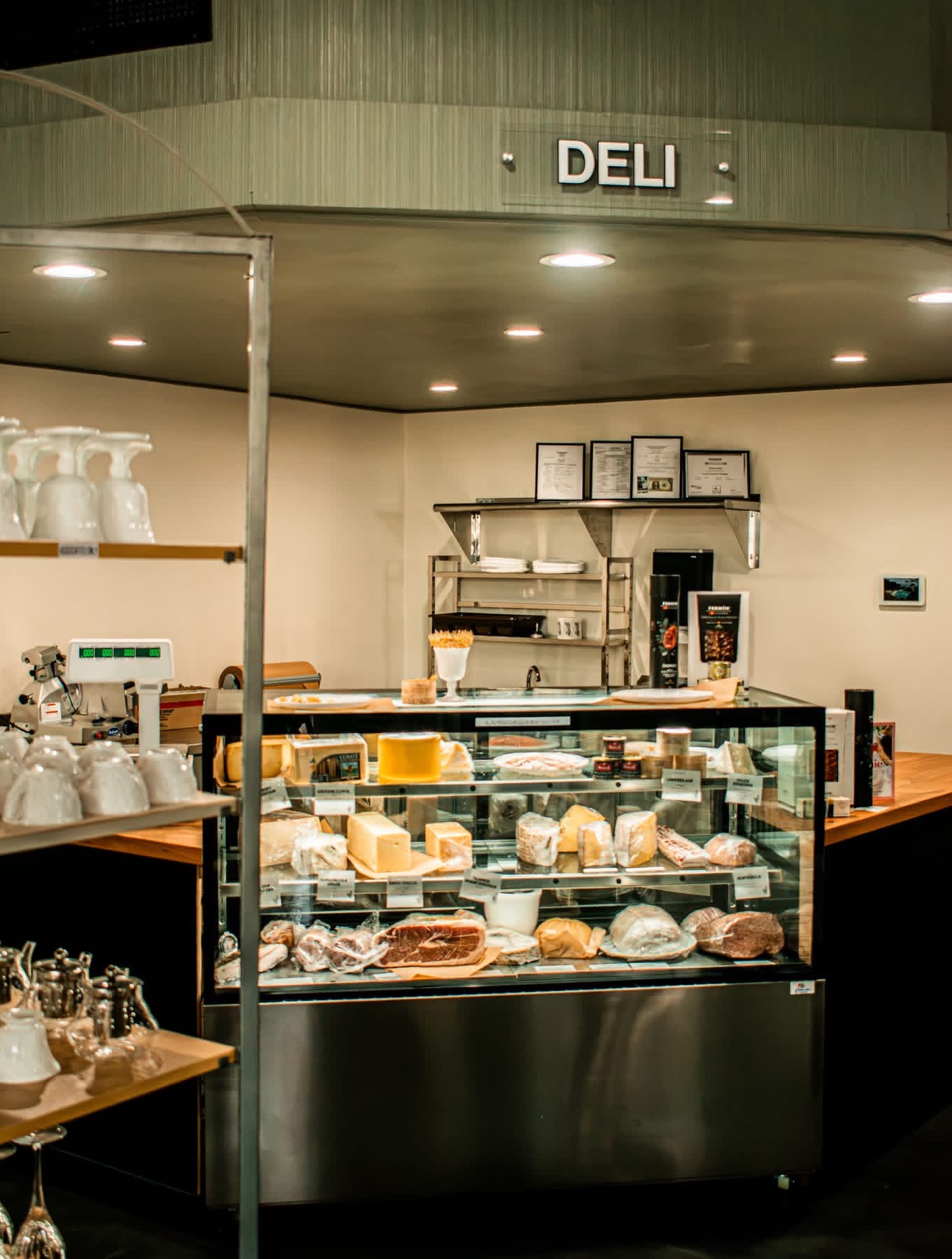 Refrigerated deli and cheese case beneath the DELI sign
