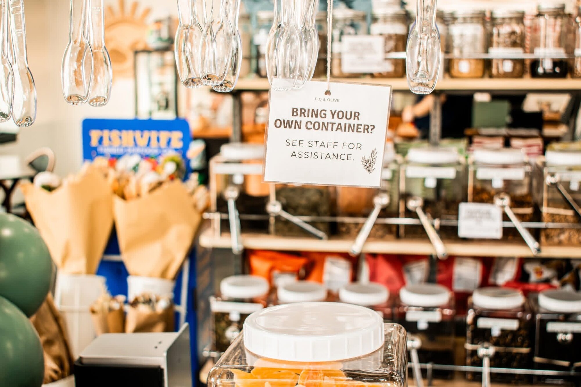 Bring-your-own-container sign hanging above the bulk refill station