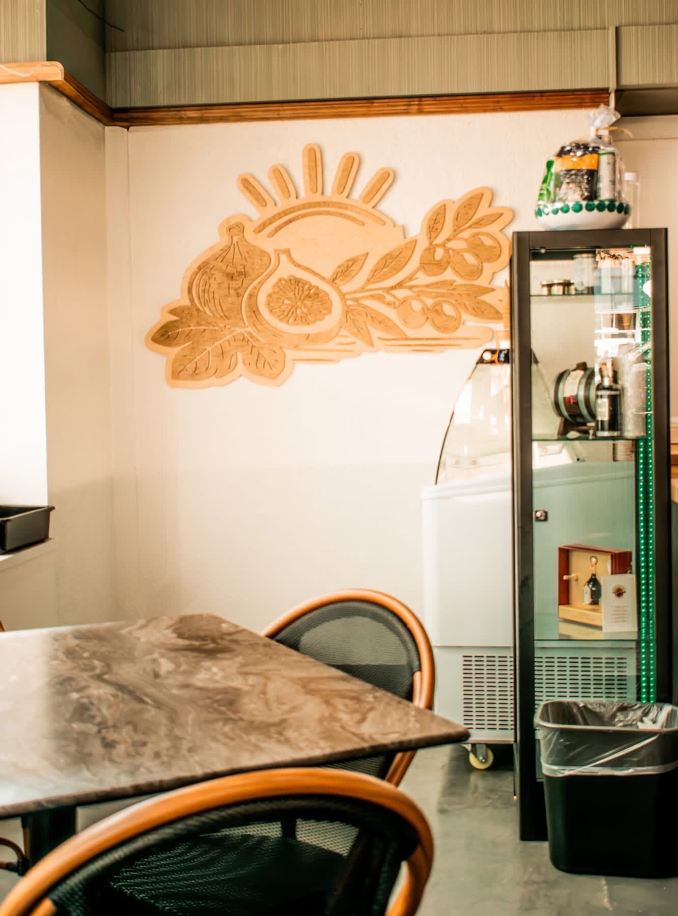 Carved fig-and-olive wall mural in the market cafe seating nook