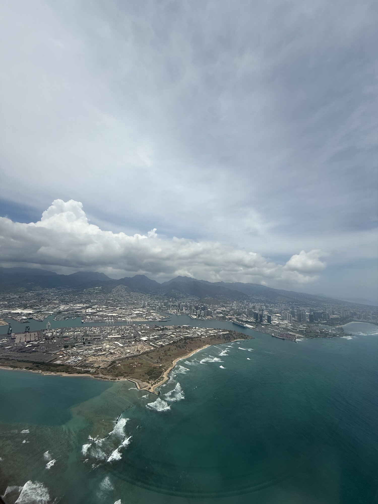 Aerial view of a Pacific coastline through dramatic clouds