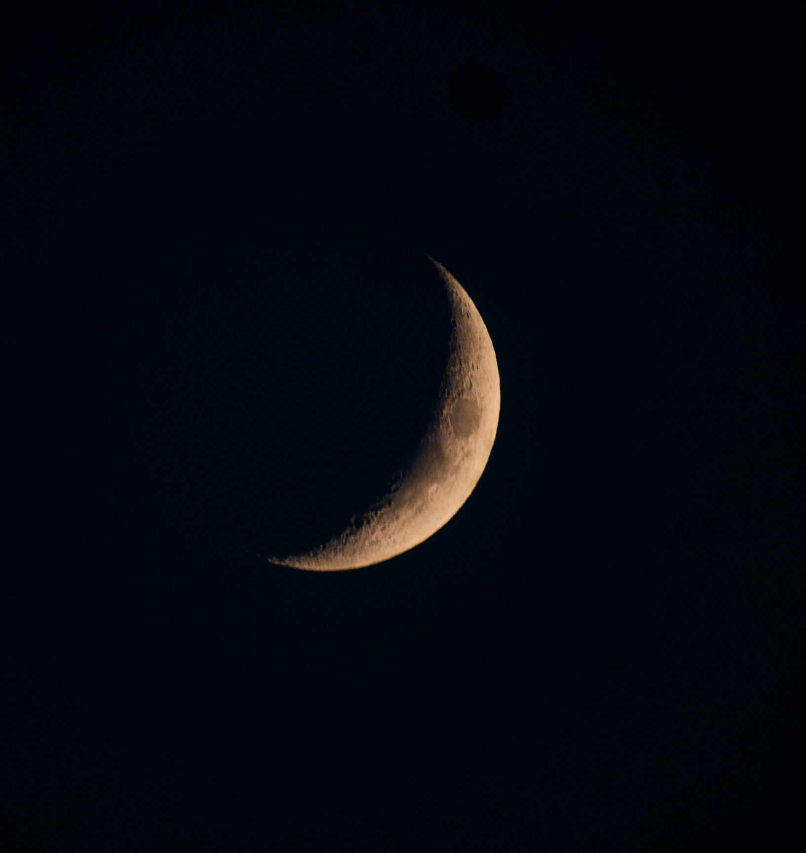 Waxing crescent moon glowing in a deep night sky