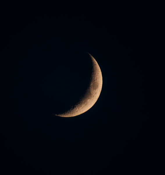 Waxing crescent moon glowing in a deep night sky
