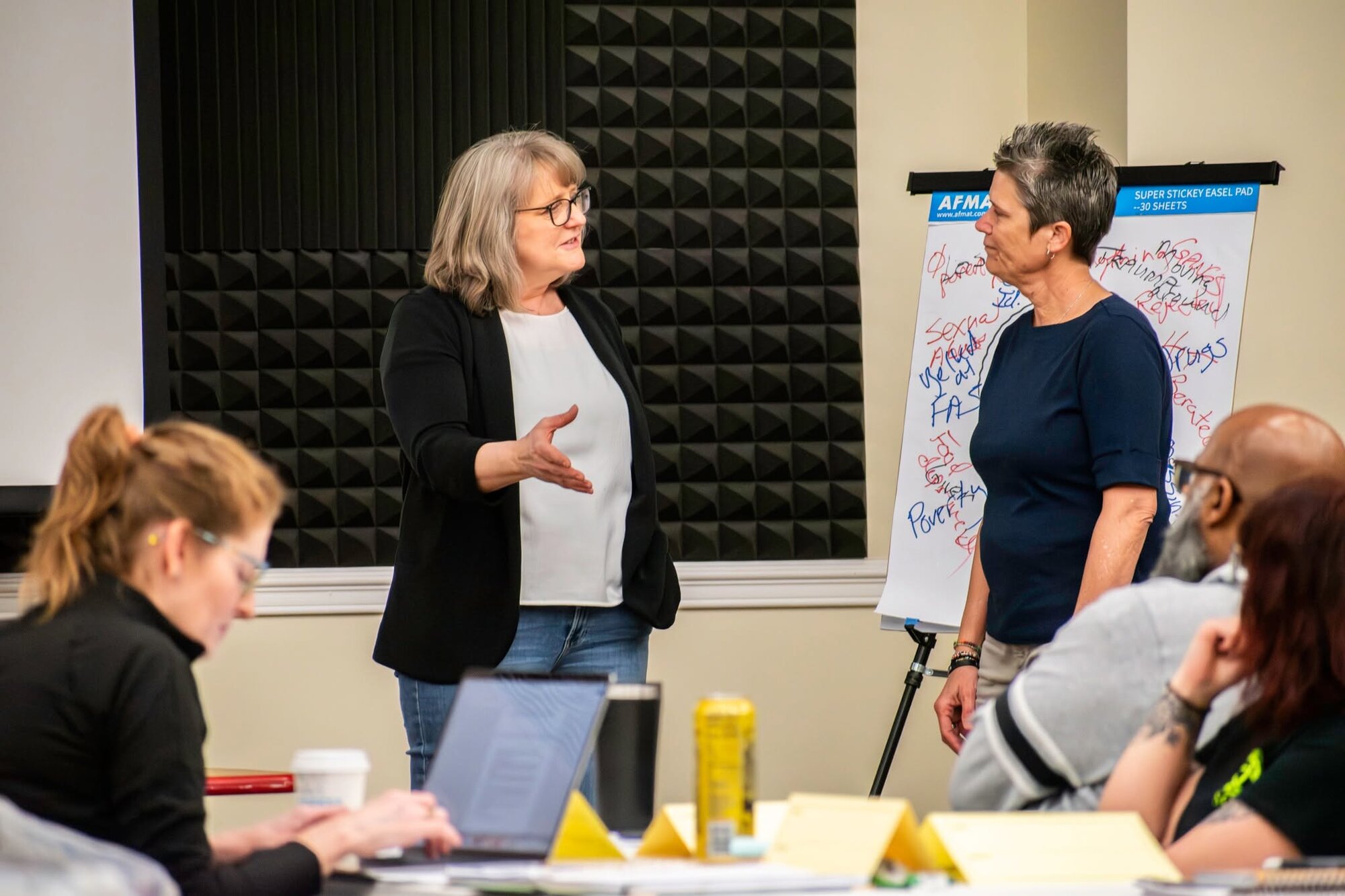 Facilitators leading a discussion with flip charts at a workshop
