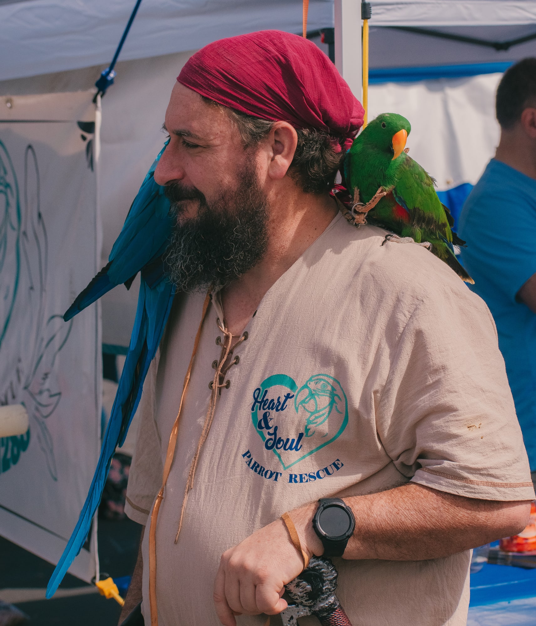 Adult bird handler with parrots on his shoulders at Grove City Agway 2026 Petfest