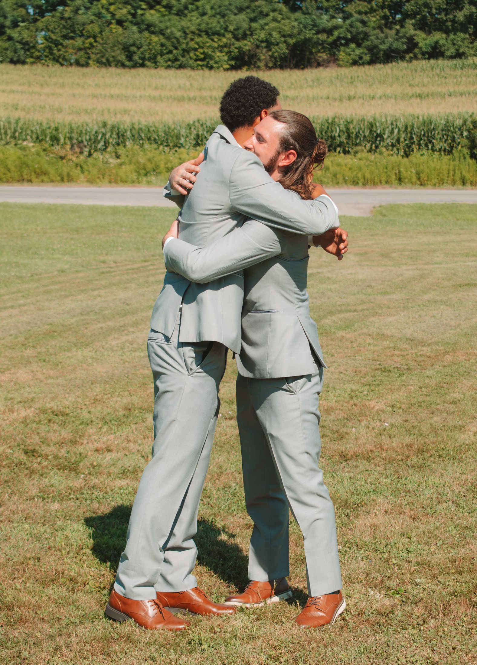 Candid close portrait of two groomsmen sharing an embrace