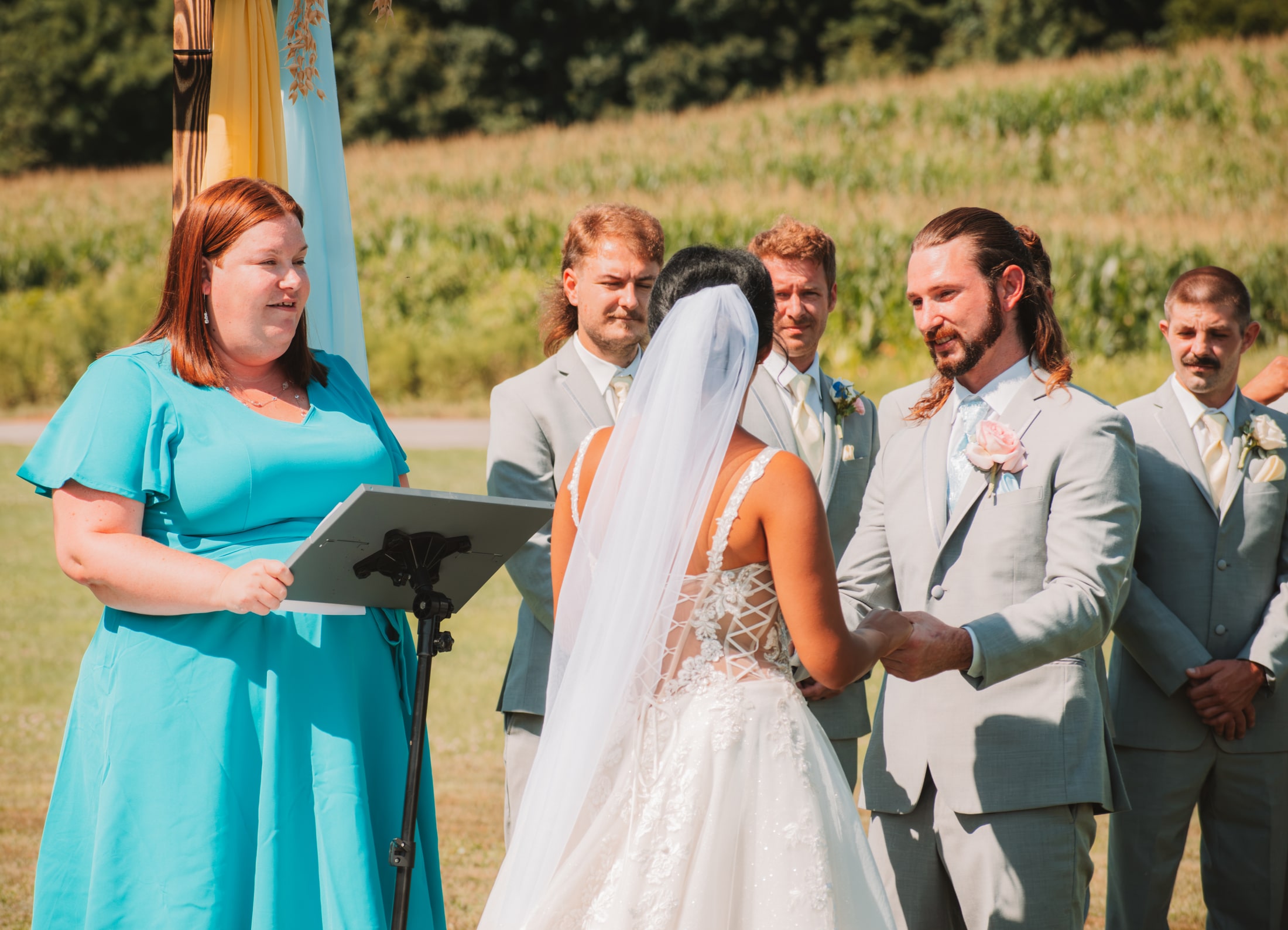 Bride laughing with the adult wedding party during the outdoor ceremony