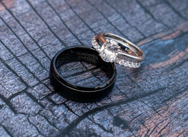 Detail photograph of the wedding rings resting on textured charred wood